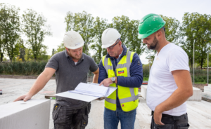 Twee mannen op de bouwplaats in gesprek met een service en support medewerker van Calduran