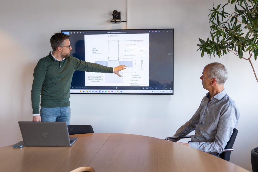 Techniek en advies medewerker van Calduran, man, geeft uitleg over kalkzandsteen met technische tekening op scherm.