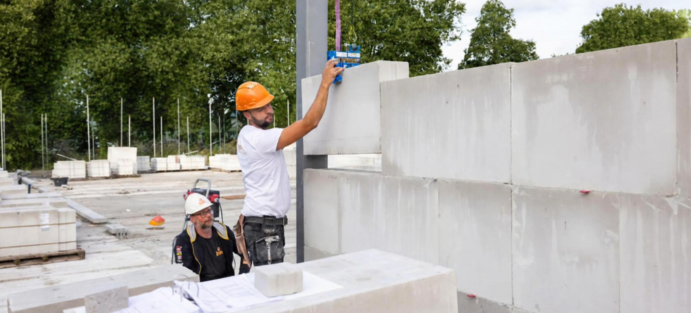Twee mannen op de bouwplaats, kalkzandsteen aan het verwerken.