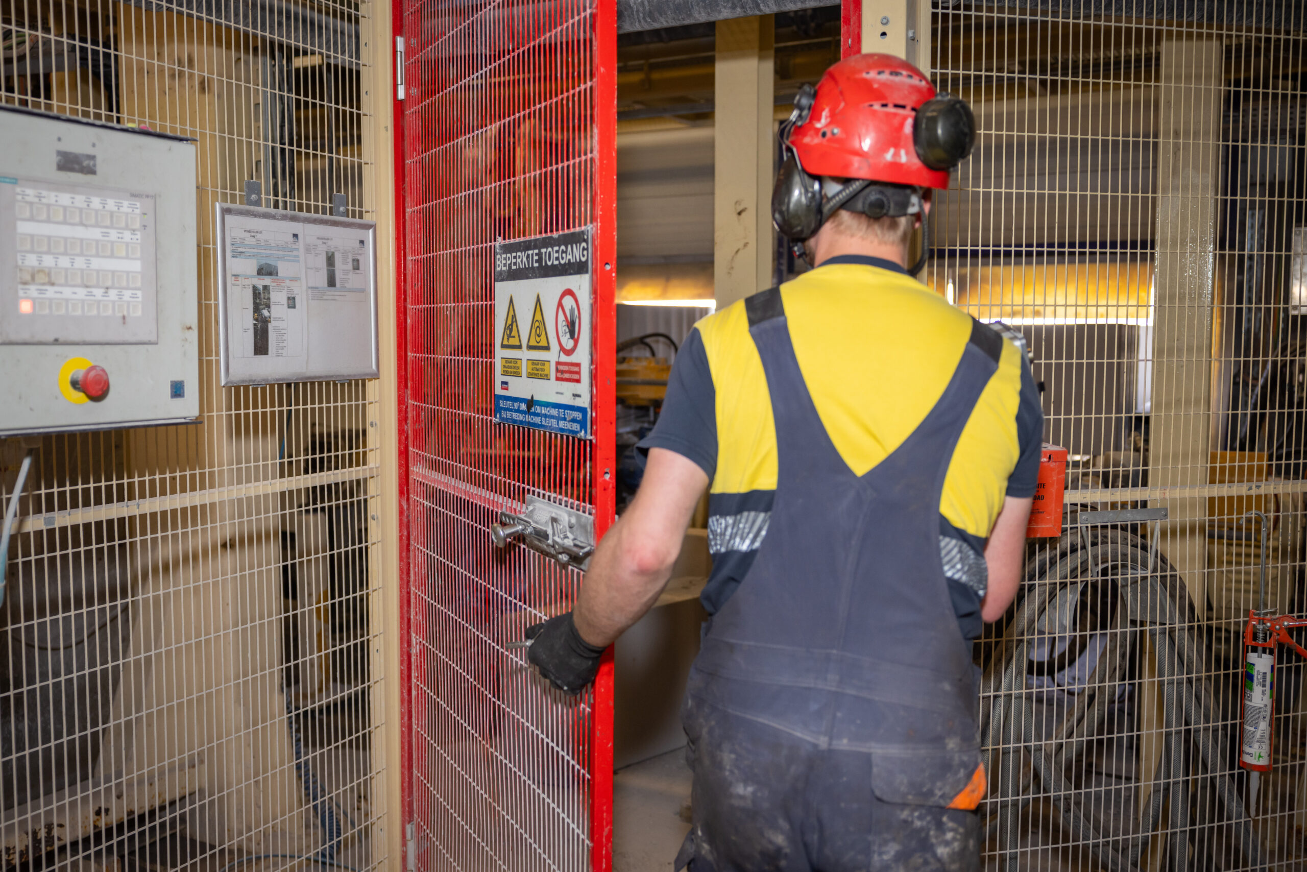Man loopt door rood veiligheidshek na het gebruik van de lockbox.